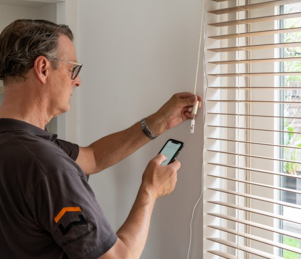 woonspecialist vakman installeert de bece® Motionblinds van houten horizontale jaloezieën