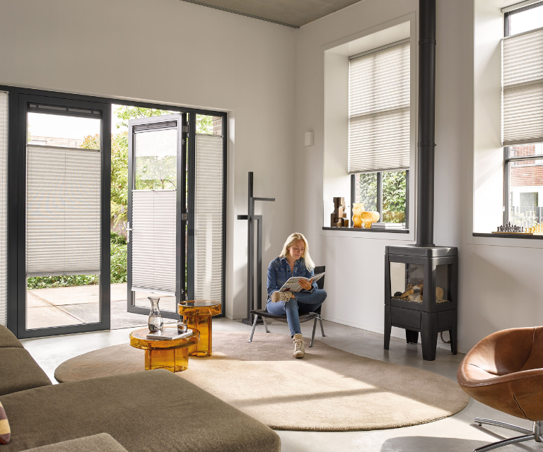 Beige plisségordijnen in de woonkamer met vloerkleden