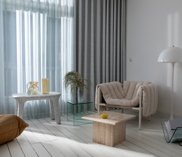 Licht grijze overgordijnen met licht blauwe inbetweens in de woonkamer