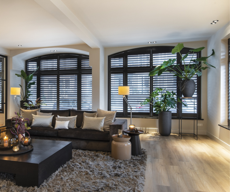 Zwarte shutters met halfronde ramen in de woonkamer