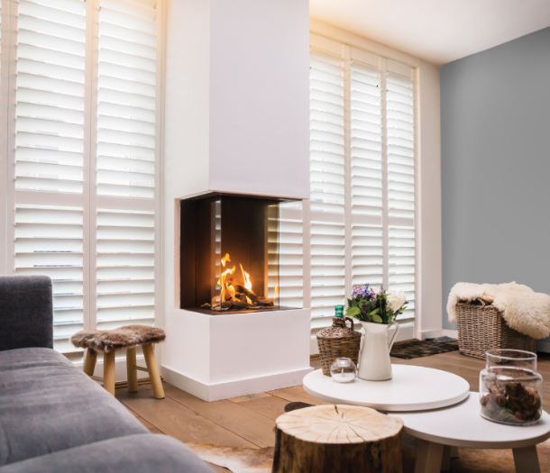 Wit shutter s in de woonkamer naast een kachel