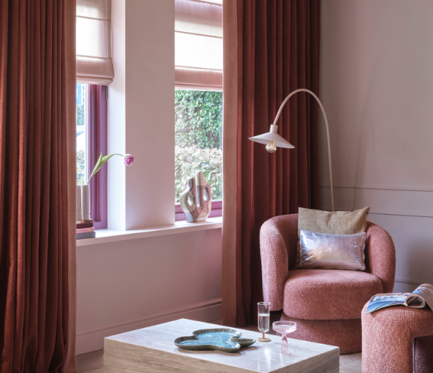 Donker rode overgordijnen en roze vouwgordijnen in de zithoek