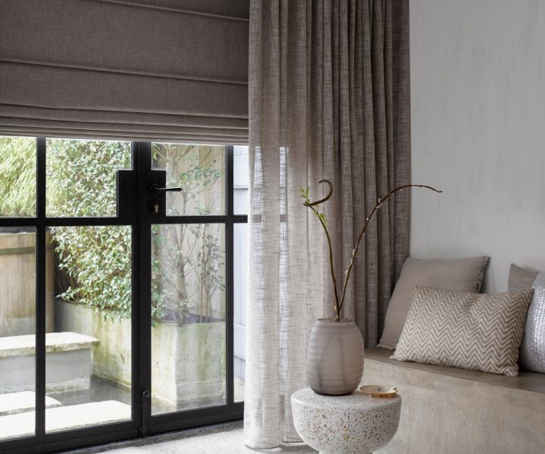 Grijze vouwgordijnen bij zwarte stalen deuren met inbetween beige